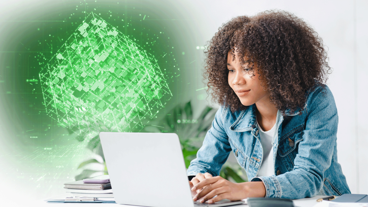 A woman working on a laptop with a green digital cube mapping data