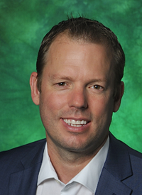 Image of faculty Bob Heere in business clothes infront of a green backdrop