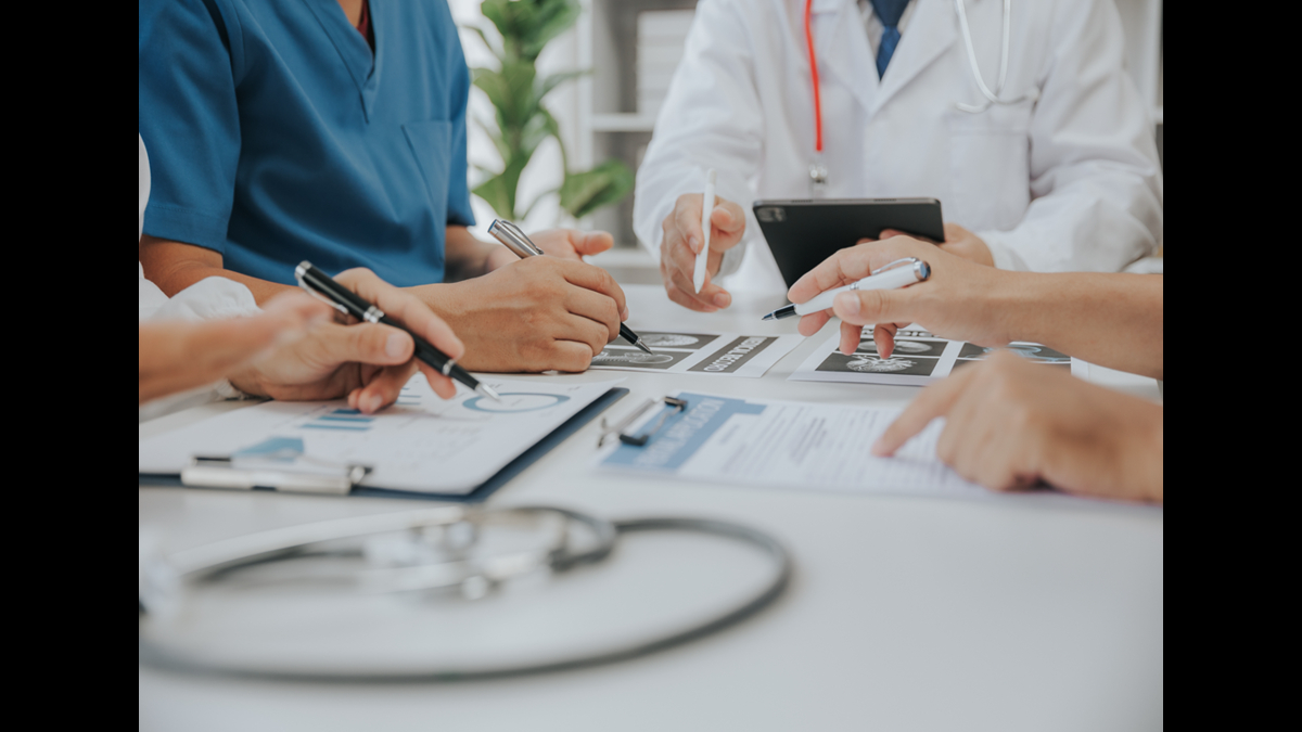 A group of medical professionals discussing charts and data during a meeting