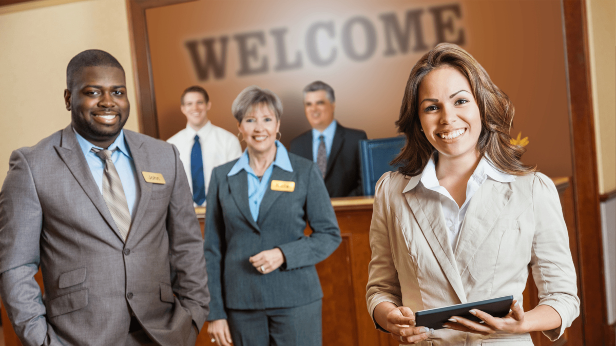 A group of smiling hotel staff standing in the lobby