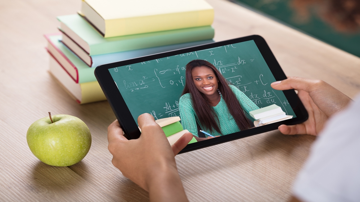 An adult student attending an online class on a tablet