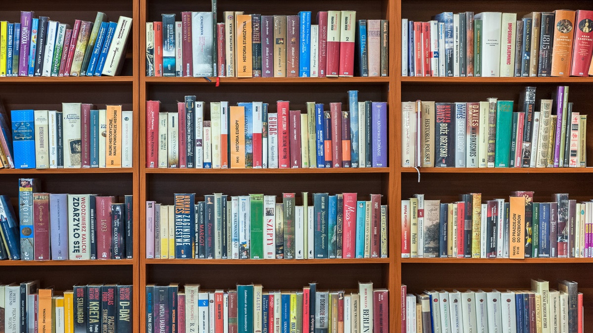 Rows of books neatly arranged on wooden shelves in a library