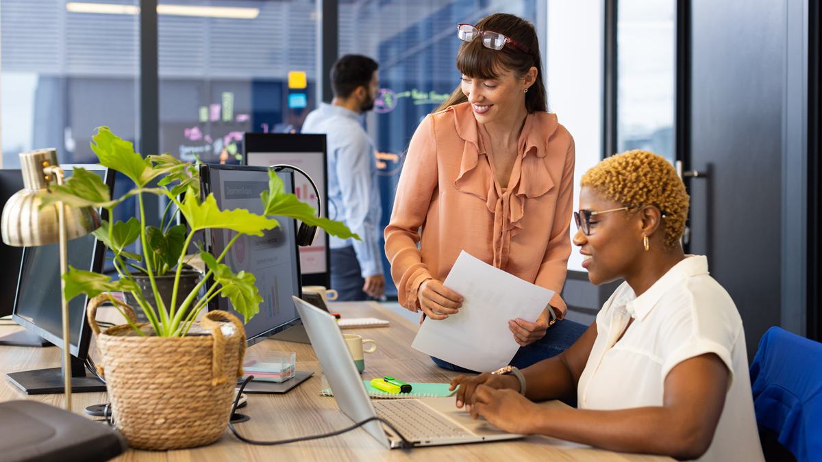 Two professional women collaborating in a modern office environment