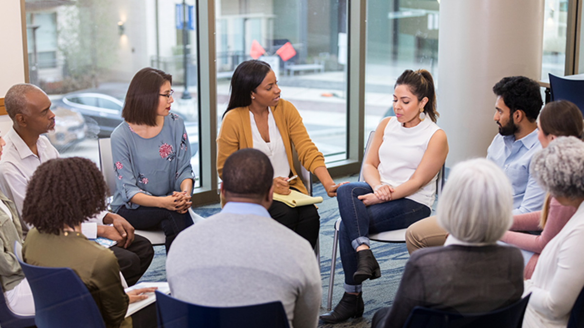 People sitting in a circle and engaging in thoughtful discussion