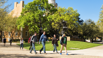 Students walking past the eagle statue on UNT campus