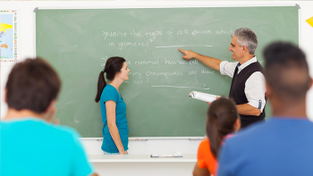 teacher helping a class of high school children