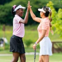 two females in golf attire giving a high-five